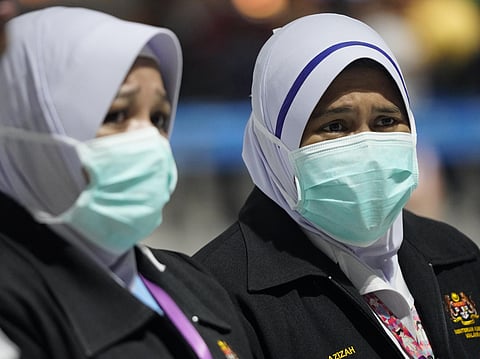 Health officials wear face masks at an inspection site at the Kuala Lumpur International Airport in Sepang, Malaysia. (Photo | AP)