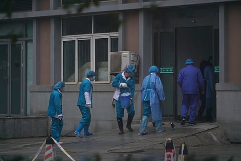 Hospital staff wash the emergency entrance of Wuhan Medical Treatment Center, where some infected with a new virus are being treated, in Wuhan, China, Wednesday, January 22, 2020.  (Photo | AP)