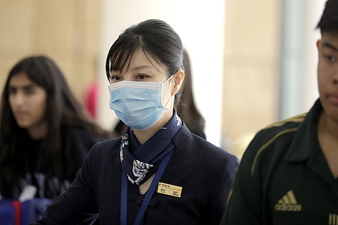 A flight crew member from China Eastern Airlines leaves the airport wearing a face mask after arriving in Sydney. (Photo | AP)