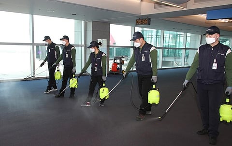 Workers from a cleaning service spray disinfectant at the customs, immigration and quarantine (CIQ) area at Incheon international airport near Seoul. (Photo| AFP)