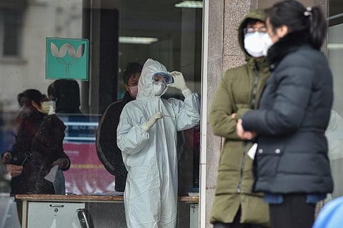 A nurse (C), wearing protective clothing to help stop the spread of a deadly virus which began in the city, looks at a thermometer at the Wuhan Fifth Hospital in Wuhan. (Photo| AFP)