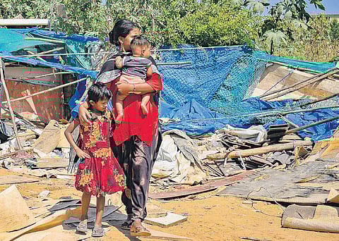 A woman and her two children lost their makeshift house in the recent demolition drive at Kariyammana Agrahara in Marathahalli on Thursday. (Photo | Saptarshi Mukherjee/EPS)