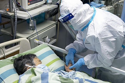 A medical worker attends to a patient in the intensive care unit at Zhongnan Hospital of Wuhan University in Wuhan in central China's Hubei Province. (Photo|Xinhua via AP)