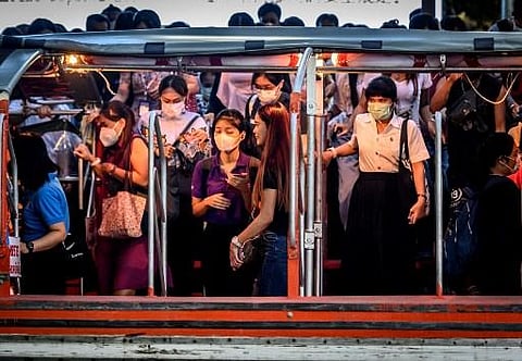 Commuters with protective facemasks board a canal boat at Pratunam Pier in Bangkok on January 30, 2020. (Photo | AFP)