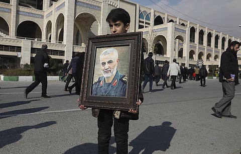 A boy carries a portrait of Iranian Revolutionary Guard Gen. Qassem Soleimani, who was killed in a U.S. airstrike in Iraq, prior to the Friday prayers in Tehran, Iran, Friday Jan. 3, 2020. (Photo | AP)