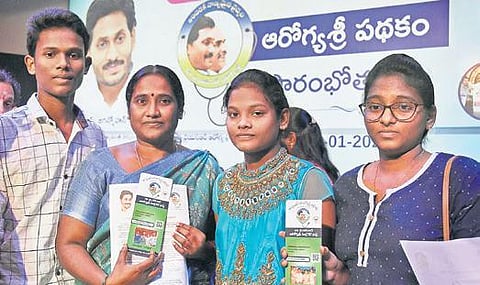 A family displaying their YSR Aarogyasri health cards. (Photo | P Ravindra Babu/EPS)