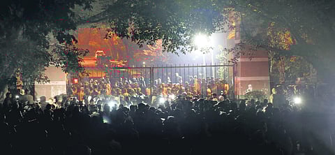Delhi Police personnel, journalists and students gather outside the Jawaharlal Nehru University campus gate, after a masked miscreants attacked several students inside the university, in New Delhi on Sunday. (Photo | Shekhar Yadav)
