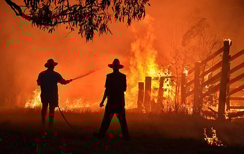 Residents defend a property from a bushfire at Hillsville near Taree, 350km north of Sydney. (File Photo | AFP)
