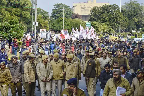Police personnel walk in front of JNU students' protest march from Mandi House to HRD Ministry demanding removal of the university vice-chancellor at Ferozeshah Road in New Delhi Thursday Jan. 9 2020. (Photo | PTI)