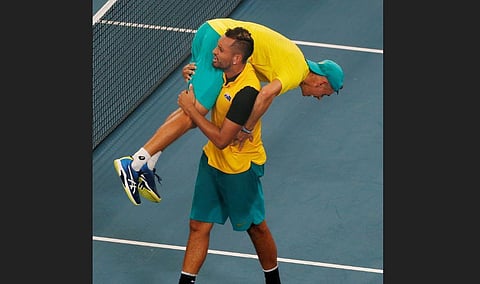 Australia's Alex De Minaur is carried by Nick Kyrgios after winning a match point against Britain's Jamie Murray and Joe Salisbury during their ATP Cup tennis doubles match. (Photo | AP)