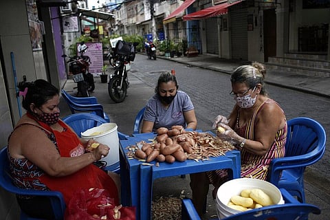 Women peel potatoes outside a snack bar amid the new coronavirus pandemic in Rio de Janeiro, Brazil, Friday, Oct. 9, 2020. (Photo | AP)