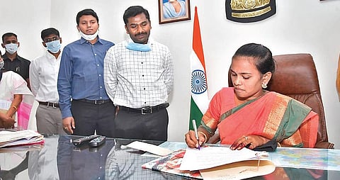 M Sravani signs a file while sitting in the Anantpur District Collector’s chair on Sunday