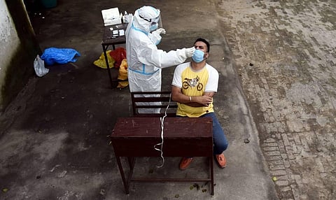 A health worker collects swab sample from a man for coronavirus rapid antigen and RT-PCR testing. (Photo | Parveen Negi, EPS)