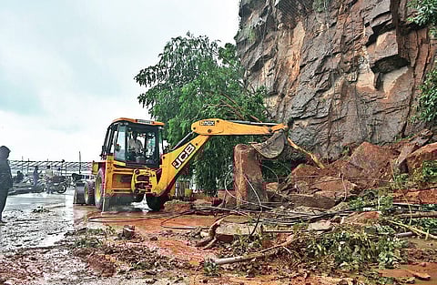 Boulders being cleared with an earthmover at ghat road of Indrakeeladri  in Vijayawada on Tuesday I Prasant Madugula