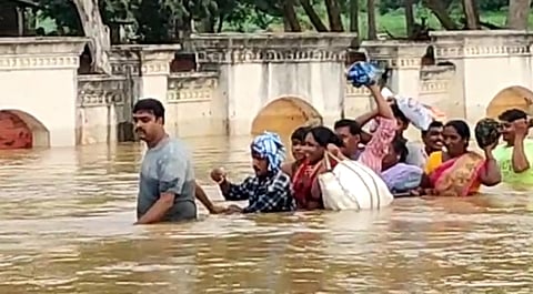 A home guard rescued nine persons who were stranded in gushing waters of river Tandava at Rayavaram in East Godavari district on Wednesday. (Photo | Express)
