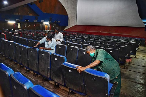 Workers clean up a theatre before its reopening. (Photo | Shriram BN, EPS)