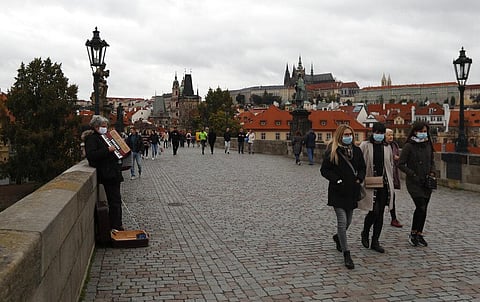 People walk across the medieval Charles Bridge in Prague, Czech Republic, Sunday, Oct. 11, 2020. (Photo | AP)