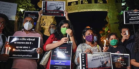 AISF activists hold placards and light candles demanding justice for the Hathras gang-rape victim. (Photo | PTI)