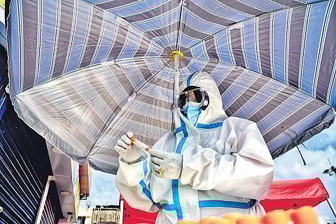 A health worker collects samples for Covid testing at the Kalasipalyam Bus Stand in Bengaluru on Saturday | Shriram BN