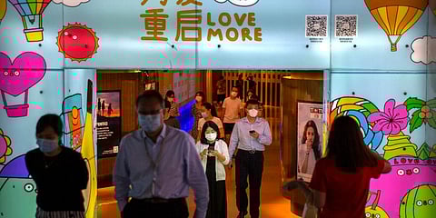 People wearing face masks to protect against the coronavirus walk through a shopping mall in Beijing. (Photo | AP)