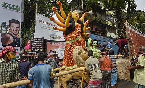 Labourers carrying an idol of Goddess Durga on their way to a puja pandal in Kolkata (Photo | PTI)
