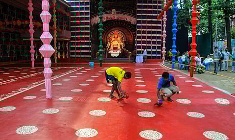 Workers clean a pandal ahead of Durga Puja festival in Kolkata Sunday Oct. 18 2020. (Photo | PTI)
