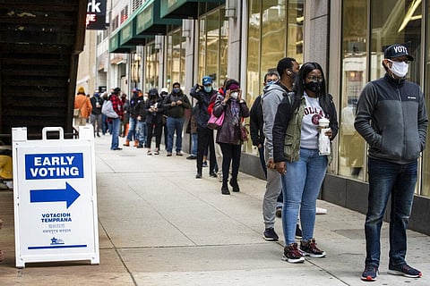 hundreds of people wait in line to early vote in Chicago. (Photo | AP)