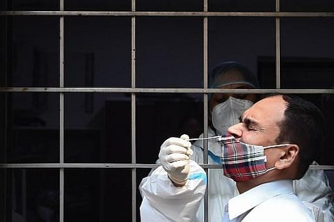 A health worker collects a swab sample from a resident to test for the Covid-19 coronavirus. (Photo| AFP)