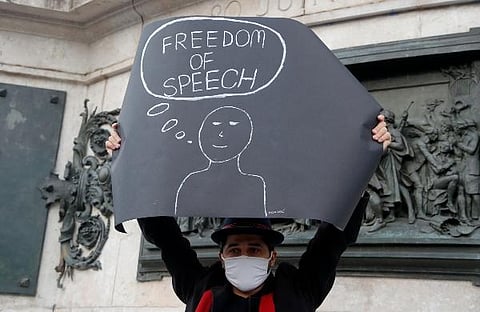 A demonstrator holds a placard on the Republique square during a demonstration in Paris. (Photo | AP)