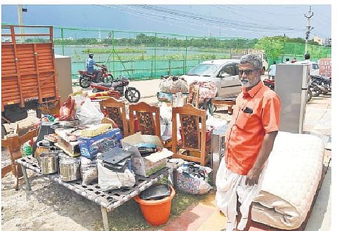 A Jillelguda resident stands helplessly by the roadside with his belongings, after he lost his home to the recent floods, on Monday | RVK Rao