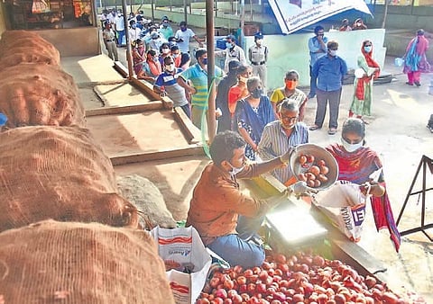 Public stand in a queue for subsidy onions at Swaraj Maidan Rythu Bazar in Vijayawada on Friday I P Ravindra Babu