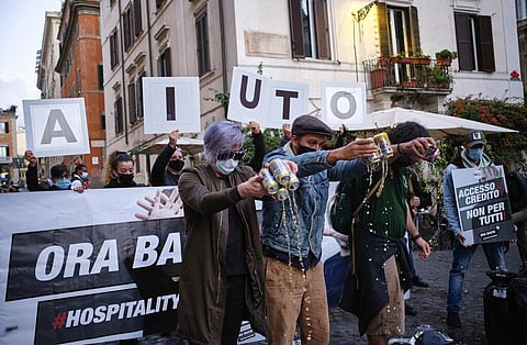 People spill beer on the ground during a protest against the government restriction measures to curb the spread of COVID-19, in Rome. (Photo | AP)