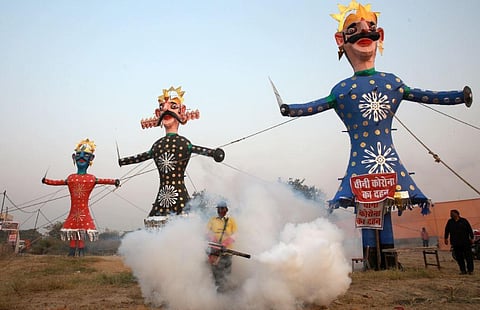 Municipal Corporation worker fumigate near the effigies of demon king Ravana Meghnad and brother Kumbhkaran installed ahead of Dussehra festival in New Delhi. (Photo | Shekhar Yadav, EPS)