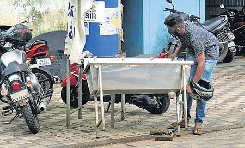 A worker removing the hand wash system in front of the corporation office which had been set up as part of Break the Chain campaign. (Photo | A Sanesh)