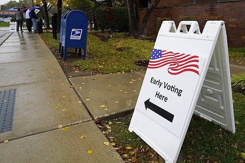 An information sign shows outside the Elk Grove Village Hall as voters wait in line during early voting at Elk Grove Village, Ill., United States. (Photo |AP)
