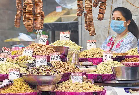A saleswoman at her dry fruits stall waits for customers at Chandni Chowk market. (Photo | EPS, Parveen Negi)