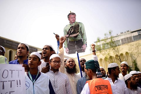 Islami Andolan Bangladesh supporters carry a French President cutout with a garland of footwear around to protest against the publishing of caricatures of the Prophet Muhammad in Dhaka. (Photo | AP)