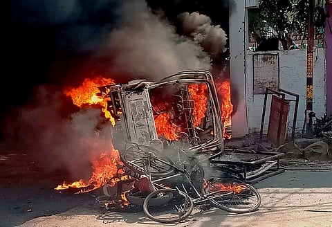 A vehicle in flames after it was set on fire by an angry mob during a protest over recent police firing during a Durga Puja event in Munger Thursday. (Photo | PTI)