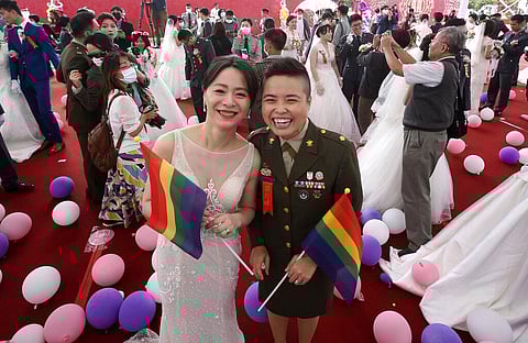 Yi Wang, right, and Yumi Meng pose during a military mass weddings ceremony in Taoyuan city, northern Taiwan, Friday, Oct. 30, 2020. (Photo | AP)