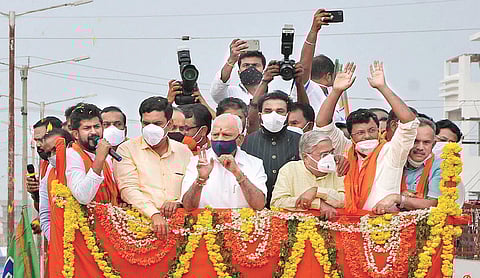 Chief Minister B S Yediyurappa takes part in a roadshow to campaign for BJP candidate Dr C M Rajesh Gowda in Sira on Friday