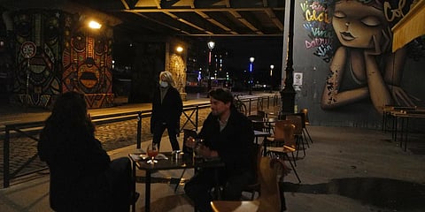 Customers enjoy on a bar terrace, a quarter before 10 pm in Paris. (File photo| AP)