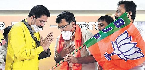 BJP state president Nalin Kumar Kateel (left) hands over a BJP flag to Dr Rajesh Gowda, who joined the party on Saturday in Bengaluru | SHRIRAM BN