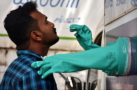 A health worker collects nasal swabs for Covid-19 from inside a sample collection unit in Chennai. (Photo | U Rakesh Kumar, EPS)