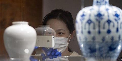 A woman wearing PPE measure against COVID-19, views artworks inside a Sotheby's auctioneers in London. (Photo | AFP)