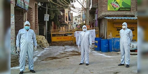 Police personnel wearing protective suits stand guard at a COVID-19 containment zone in South Delhi. (Photo | PTI)