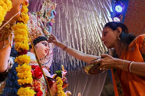 A devotee applying vermilion to the idol of goddess Durga (Photo | PTI)