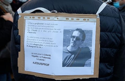 A demonstrator displays on his back a portrait of slain teacher Samuel Paty during a demonstration in Paris. (Photo | AP)