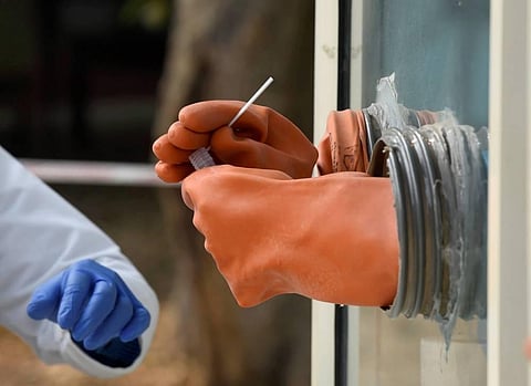 A health worker collects swab sample in a tube for the COVID-19 test. (Photo | PTI)