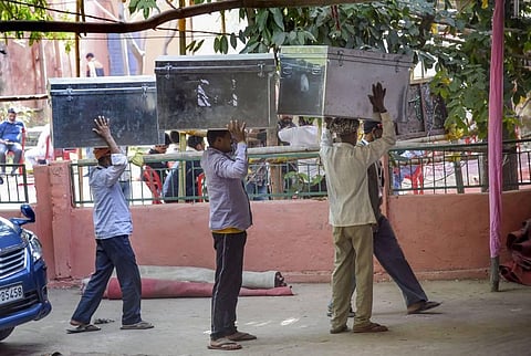 Workers return Electronic Voting Machines EVMs to a strong room during counting day of Bihar Assembly polls in Patna. (Photo | PTI)