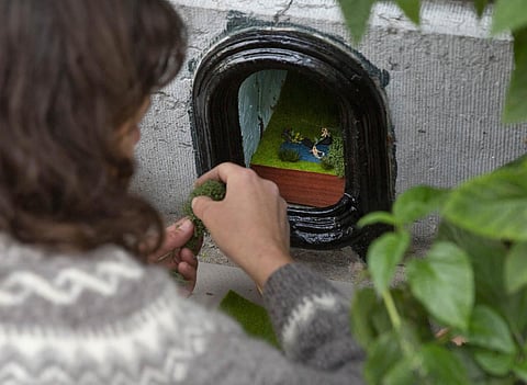 Belgian artist Elke Lemmens installs a miniature scene of a girl on a horse at the seaside into a boot scraper in Antwerp, Belgium, Sunday, Oct. 25, 2020. Lemmens is transforming disused boot scrapers in the port city of Antwerp into miniature scenes depicting what is important in the lives of the owners of the house. (Photo | AP)